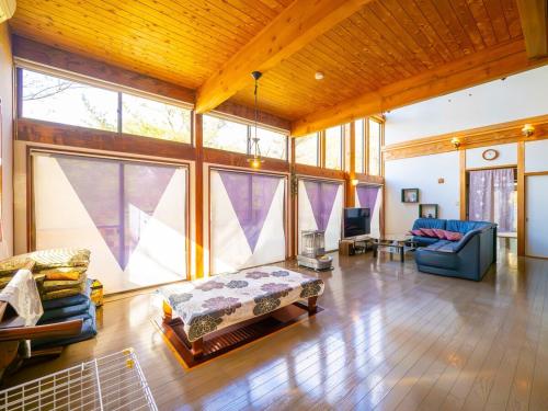a large living room with a couch and some windows at Beautiful Nasu, the center of Nasu, Up to 12 people, 3 bedrooms, BBQ on the deck, night karaoke in Nasu