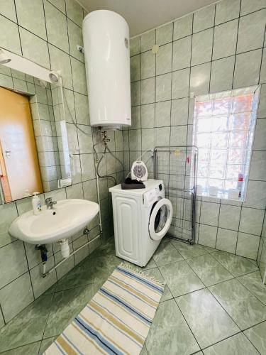 a bathroom with a washing machine and a sink at GreenPark Candy Manor with Large Garden Close to Tokaj in Bekecs