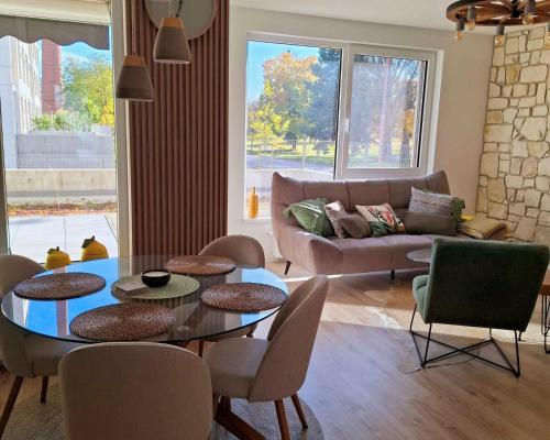 ein Wohnzimmer mit Tisch, Stühlen und Sofa in der Unterkunft Sugar Apartment 41A in Trnava