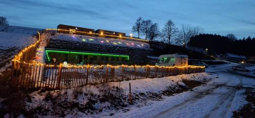 ein Gebäude mit Weihnachtslichtern im Schnee in der Unterkunft Modularhouses Nochilinga in Nöchling