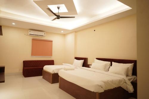 Dos camas en una habitación de hotel con un proyector. en Hotel The Grand Ranjeet, en Indore