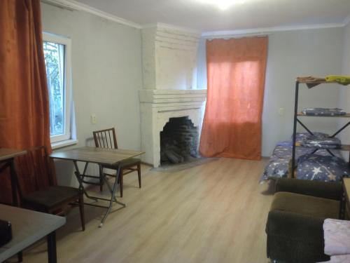un soggiorno con camino, tavolo e letto di studio with a fireplace a Zugdidi