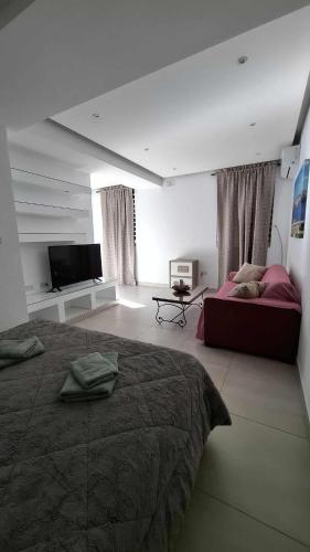 a bedroom with a bed and a flat screen tv at Cosy studio close to Qawra Beach in St. Paul's Bay