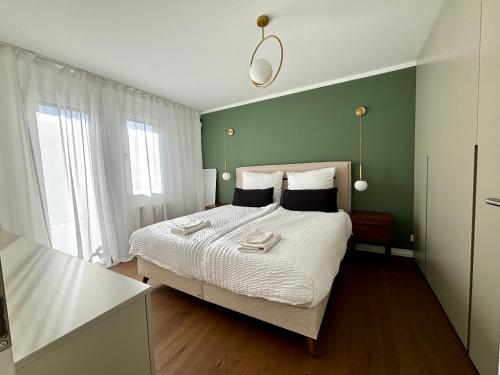 Un dormitorio con una cama y una pared verde. en Modern and Peaceful Renovated Apartment in Riehen, en Riehen