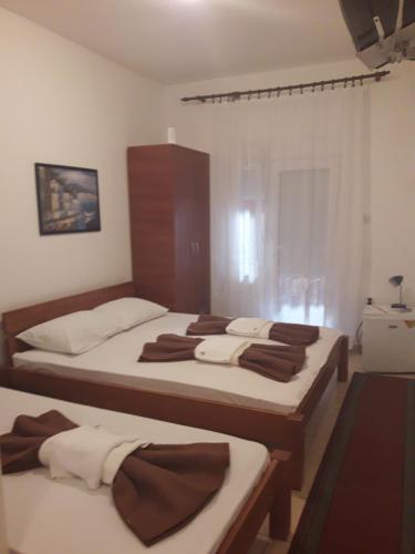 1 dormitorio con 3 camas y toallas. en Rooms Kuljic, en Budva