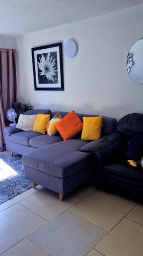 a living room with a blue couch with colorful pillows at 2bed city centre apartment in Limerick