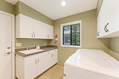 a kitchen with white cabinets and a sink at 10 Tan Oak in Sunriver