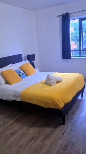 a bedroom with two beds with yellow sheets and a window at 2bed city centre apartment in Limerick
