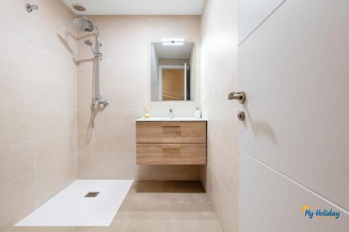 une salle de bains blanche avec un lavabo et un miroir dans l'établissement Villa Meloneras III, à Maspalomas