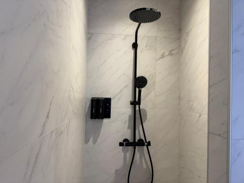 a shower with a black shower head in a bathroom at Maastricht Suites - City Studio A in Maastricht