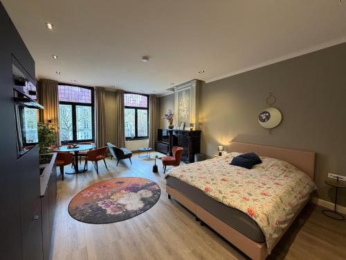 a bedroom with a bed and a table and chairs at Maastricht Suites - City Studio A in Maastricht