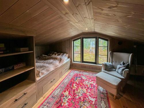 a bedroom with a bed and a chair and a rug at Architect Mountain Cabin At Lygna With Views in Jaren