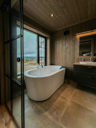 a large bath tub in a bathroom with a window at Architect Mountain Cabin At Lygna With Views in Jaren