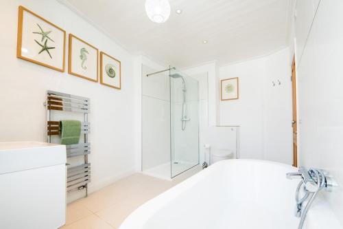 een witte badkamer met douche en wastafel bij 70 Trefusis in Flushing