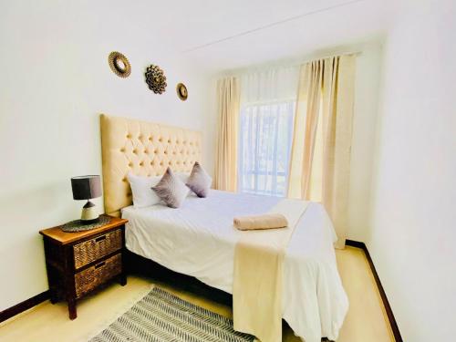 a white bedroom with a bed and a window at Siena Sun Celebration House Party friendly noise tolerant in Midrand