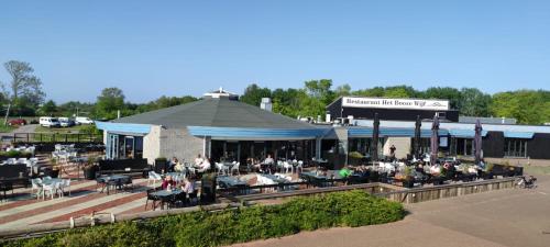 un gruppo di persone sedute fuori da un edificio di MOBILHEIM HERZ LAUWERSOOG - Chalet Schildhoek a Lauwersoog
