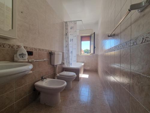 a bathroom with two toilets and a sink and a shower at House Calamigna in Ventimiglia di Sicilia