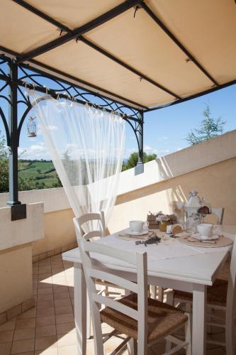 a white table and chairs on a patio with a window at La Pulcia B&B in Gradara
