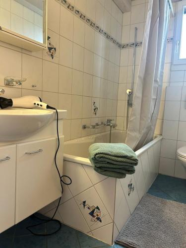 a white bathroom with a sink and a shower at Ferienwohnung mit Herz in Schwyz