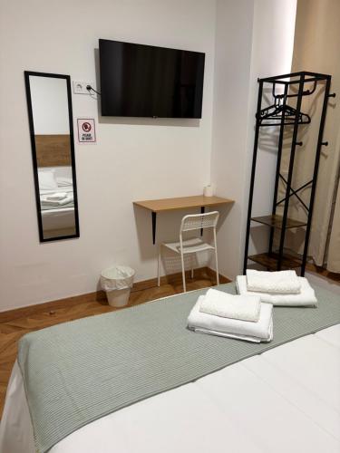 een slaapkamer met een bed met 2 handdoeken en een spiegel bij B&B Valencia in Valencia