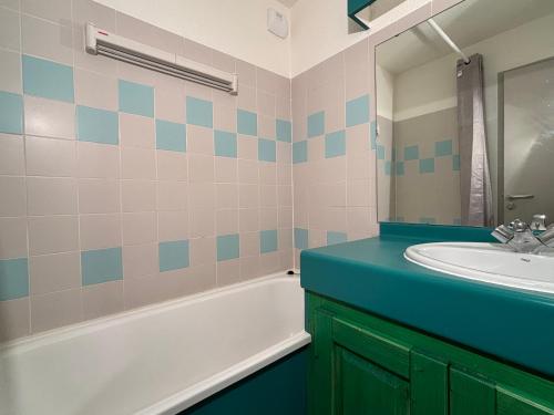 ein Badezimmer mit Waschbecken, Badewanne und Spiegel in der Unterkunft Résidence Grand Bois A1118 Clés Blanches in La Tania