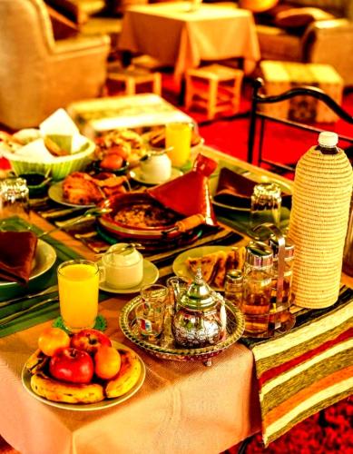 ein Tisch mit Tellern voller Speisen und Getränken in der Unterkunft Romantic Luxury Camp in Merzouga