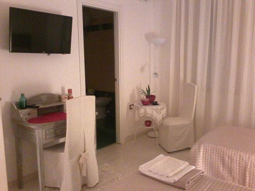 a bedroom with a bed and a desk and a television at B&B Liberty in Santa Maria Capua Vetere