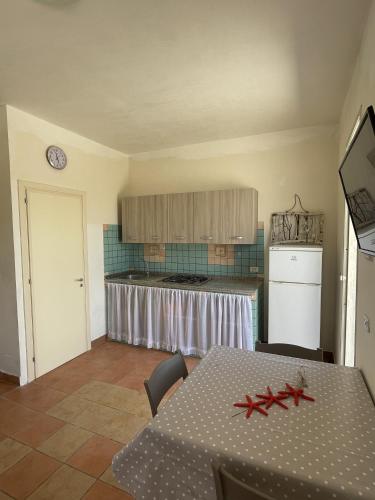 a dining room with a table and a kitchen at Villa Tony - Baia Verde Only Teenagers in Baia Verde
