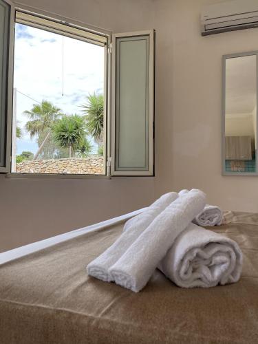 a white room with a bed with a white towel at Villa Tony - Baia Verde Only Teenagers in Baia Verde