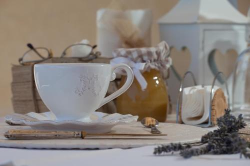 a white cup and saucers on a table at La Pulcia B&B in Gradara