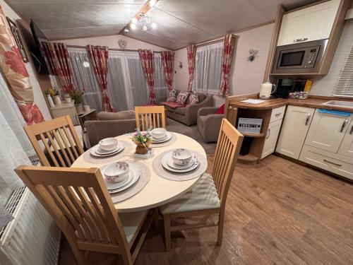 Una cocina y un comedor con mesa y sillas. en Carnaby Rosedale, en Crowle