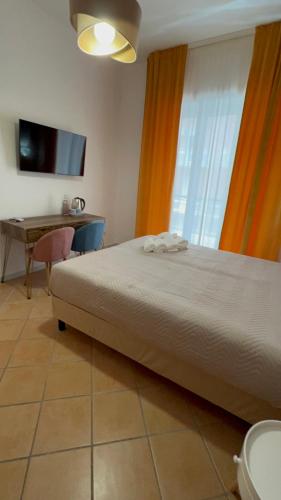 een slaapkamer met een bed, een bureau en een televisie bij Le Corti del Re Tappia in Napels