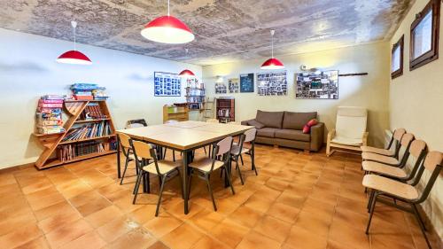 uma sala com uma mesa, cadeiras e um sofá em El Refugio de Enveitg em Enveitg