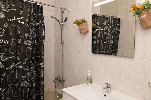a bathroom with a shower curtain and a sink at FiloApartment in Peniche