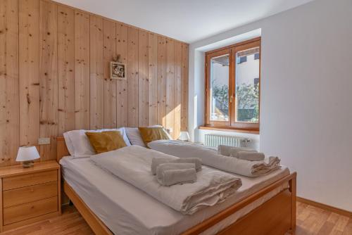 a large bed in a room with wooden walls at Trilo La Rindela in Folgaria