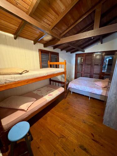 a room with two bunk beds and a stool at Residencial Solar del Nieto in Garopaba