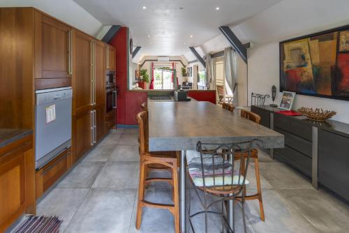 a kitchen with a large wooden table and chairs at Le Flamboyant 309, magnifique appartement avec piscine in Saint-Gilles les Bains