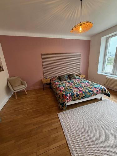 a bedroom with a bed and a chair and a window at Le Refuge de Raoul in Montier-en-Der