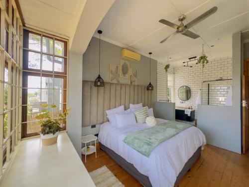 LadyBird Cottage في ديربان: غرفة نوم بها سرير ومروحة سقف