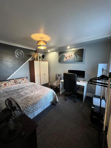 a bedroom with a bed and a desk with a computer at accommodation near Luton city centre in Luton