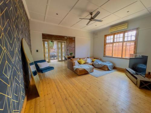 LadyBird Cottage في ديربان: غرفة معيشة مع أريكة وجدار