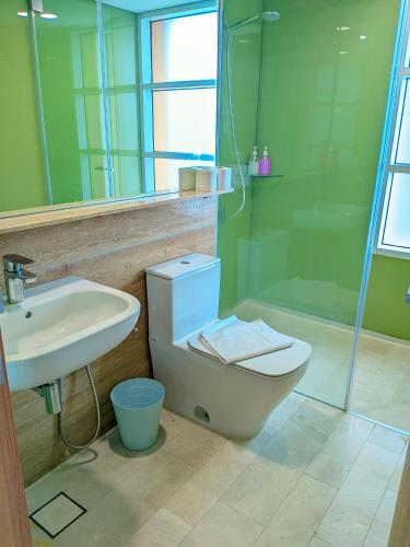 a bathroom with a toilet and a sink and a shower at Sky Suites KLCC Kuala Lumpur LB in Kuala Lumpur