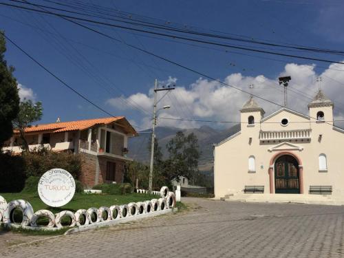 a white church with a sign in front of it at Pakarina Hospedaje in Cotacachi