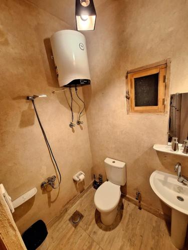 a bathroom with a toilet and a sink at El-Beit in Siwa