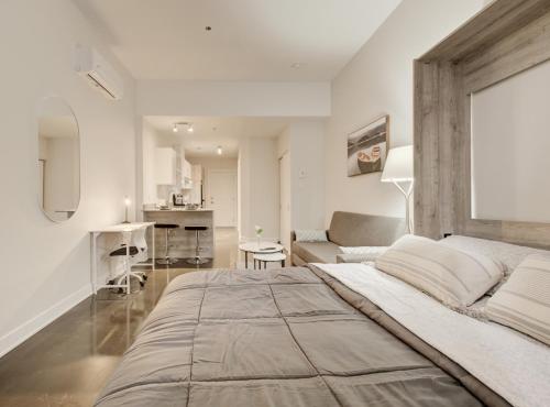 a bedroom with a large bed and a living room at Confort et style en plein Montréal in Montréal