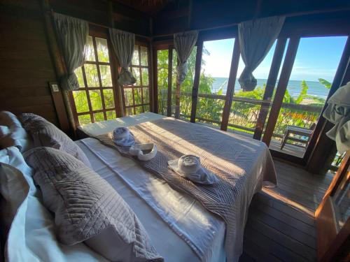 a bedroom with a bed with a view of the ocean at Villa Caravelas Praia de Moitas in Amontada