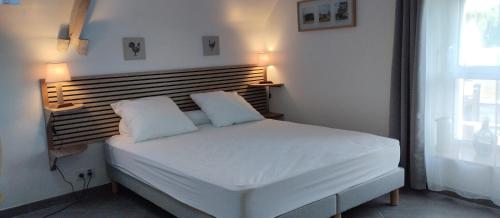 ein Schlafzimmer mit einem weißen Bett und zwei Kissen in der Unterkunft La grange du Manemeur in Quiberon