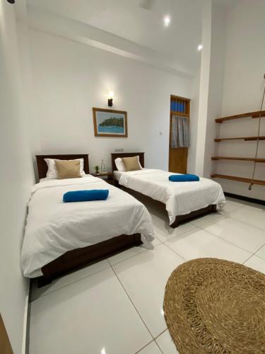 a bedroom with two beds and a rug at Surf'n Lanka - Surf School in Weligama
