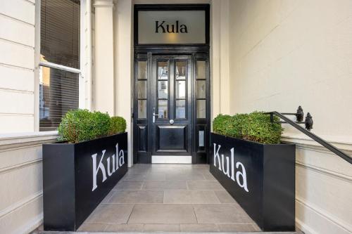 a kilt entrance to a building with a black door at Kula London - Kensington in London