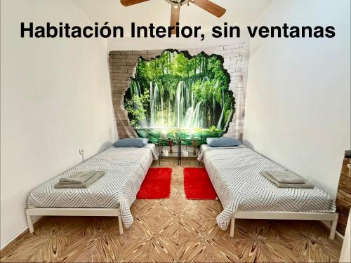 2 bedden in een kamer met een watervalmuurschildering bij Rooms La Laja 3 in Las Palmas de Gran Canaria